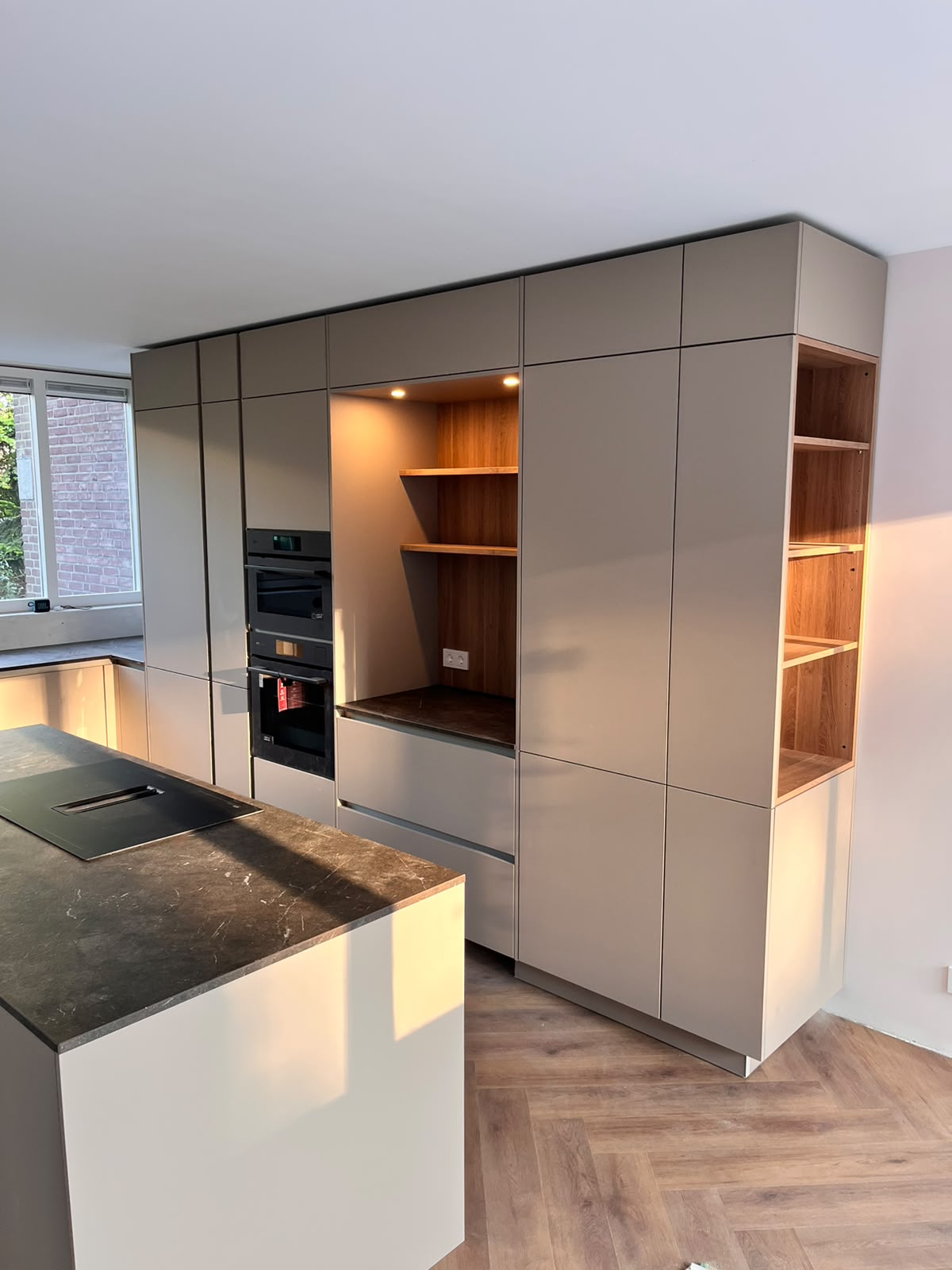 Kastenwand met nis, eiken schappen en sfeerverlichting