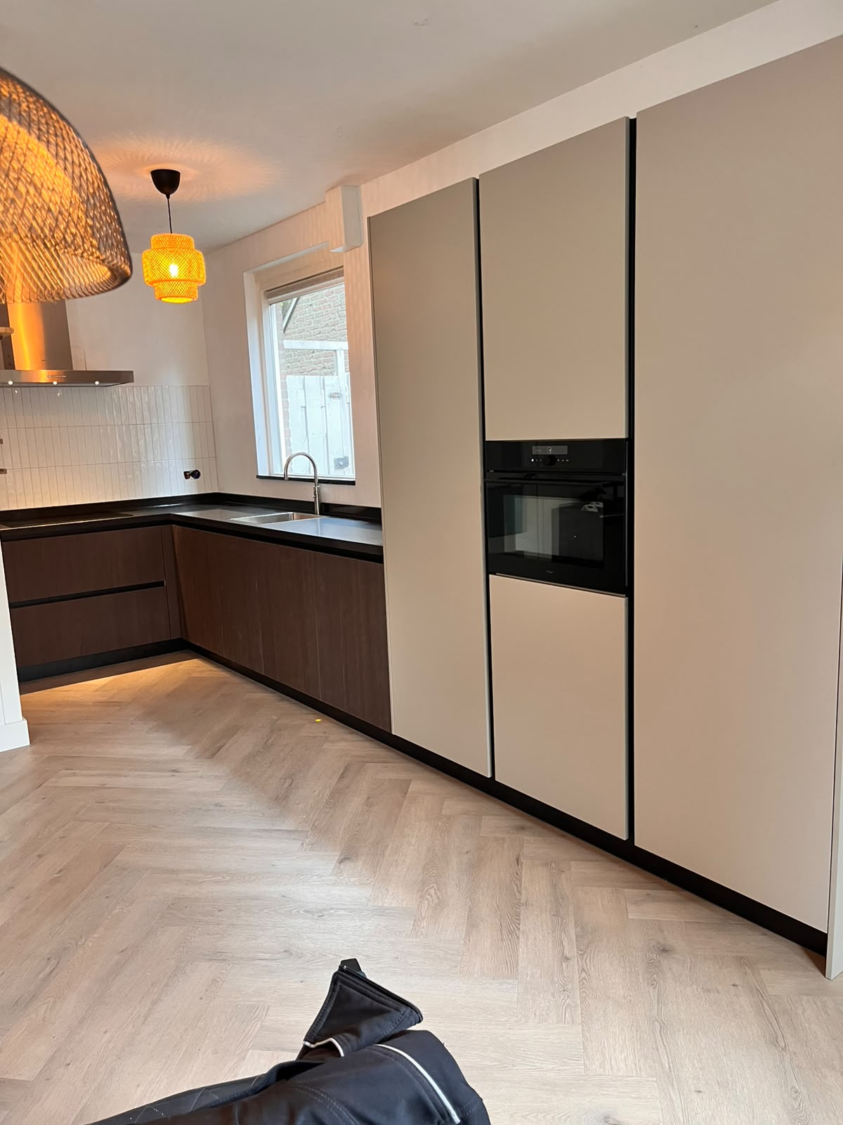 Keuken met hoge kastenwand in zand en donker hout