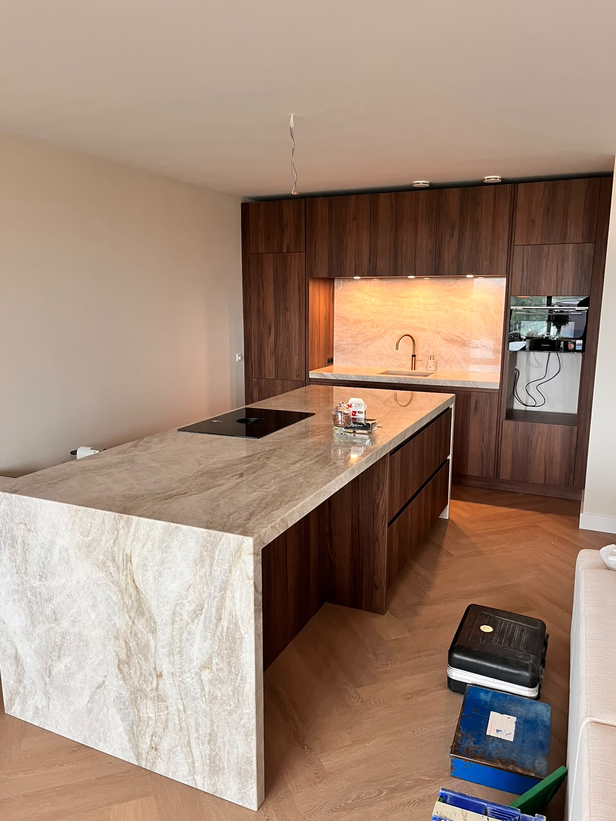Notenhouten keuken met marmeren eiland en gouden kraan
